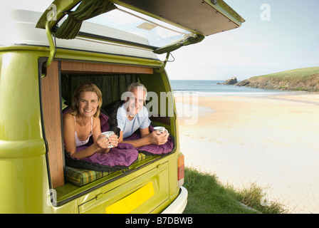 Mature couple lying in camper van Stock Photo