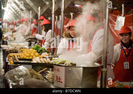 Vendors at a food stall in Donghuamen street night food market in Beijing 2009 Stock Photo