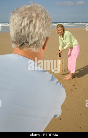 Couple playing cricket on a beach Stock Photo
