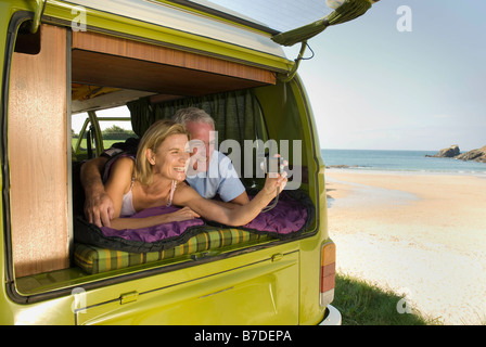 Mature couple lying in camper van Stock Photo