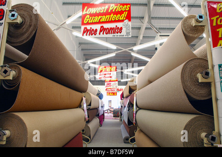 Large rolls of carpet for sale in Carpet Right with a lowest price guaranteed sign displayed from the ceiling Stock Photo