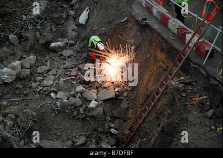 A workman using oxyacetylene cutting to remove steel reinforcement bars after the concrete had been removed with a pile driver Stock Photo