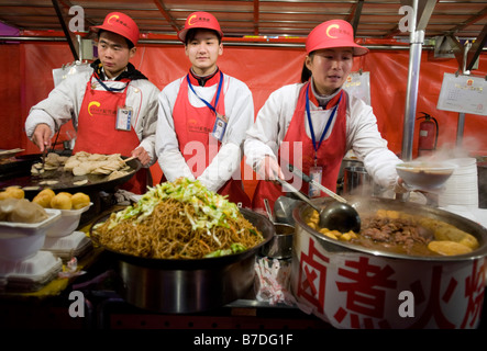 Vendors at a food stall in Donghuamen street night food market in Beijing 2009 Stock Photo