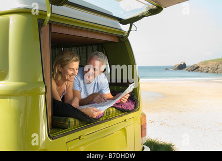 Mature couple lying in camper van Stock Photo