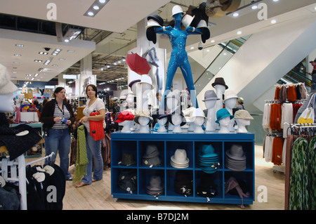 Various hats for sale in Top Shop displayed on a big blue shop mannequin Stock Photo