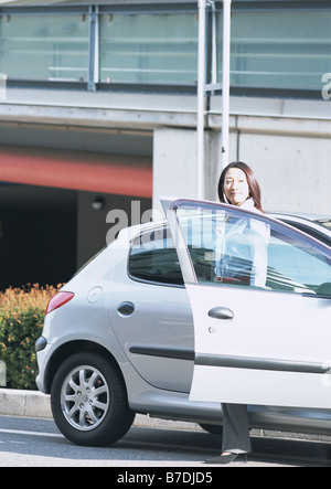 Business woman getting off a car Stock Photo - Alamy