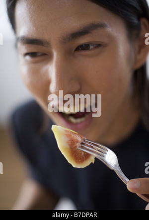 Man eating fig Stock Photo