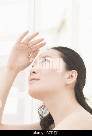 Woman shielding eyes from sun Stock Photo