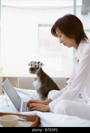 Woman using laptop on bed Stock Photo