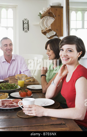 Daughter sat at dining table with her father and daughter Stock Photo