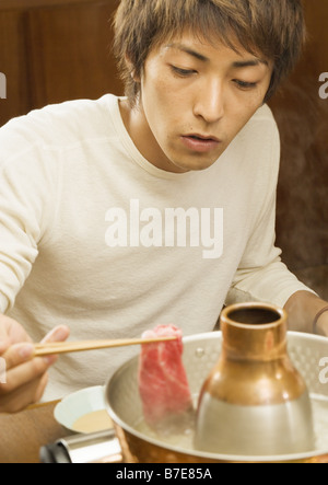 Man Eating Beef One-Pot Stock Photo