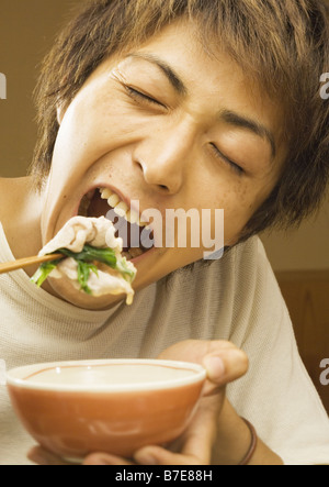 Man Eating Beef One-Pot Stock Photo