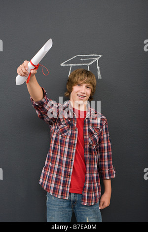 A boy holding a scroll and a chalk mortar board Stock Photo