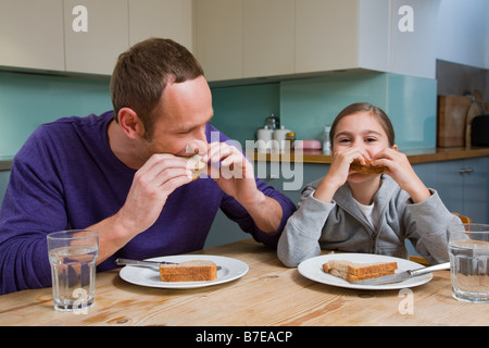 Father and daughter eating sandwiches Stock Photo