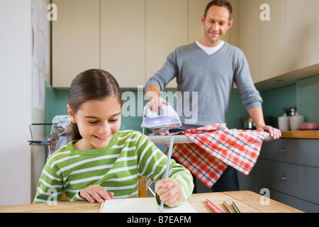 Father watching daughter colouring in Stock Photo