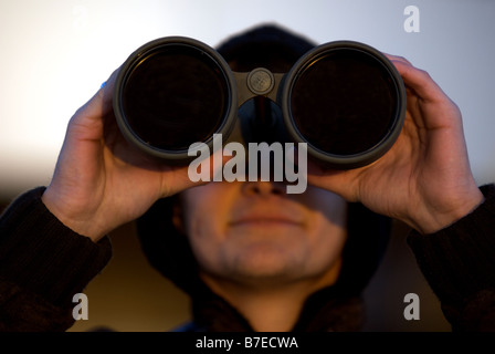 Plane spotter using powerful binoculars to watch aircraft at Dusseldorf International Airport, Germany. Stock Photo