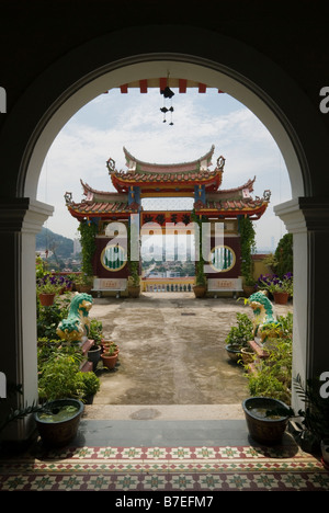 An arched doorway frames a traditional ornate gateway with views over Georgetown at the Buddhist Kek Lok Si Temple, Air Itam, Penang, Malaysia Stock Photo