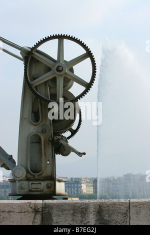 Crane at the side of Lake Geneva with a large fountain behind Stock Photo