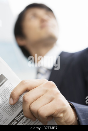 Close-up of businessman's hand holding a newspaper Stock Photo