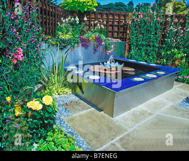 WATER FEATURE BASED ON STAINLESS STEEL WITH PLANTED RAISED BEDS Stock Photo