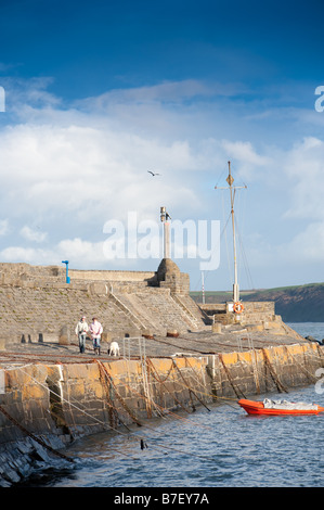 people walking in New Quay harbour Ceredigion Wales UK, on a clear bright January winter afternoon Stock Photo