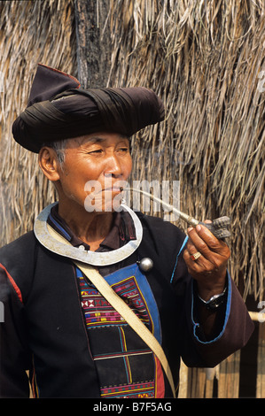 Portrait of Akha Man from northern Thai Hill tribe Smoking Opium Pipe, near Chiang Rai, northern Thailand Stock Photo