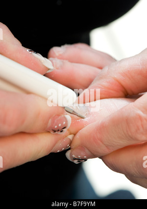 Foot therapist working on a pair of feet removing dead tissue around the nail Stock Photo