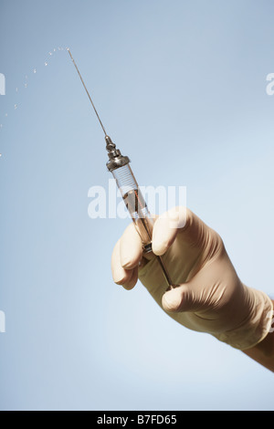 Hand holding an old fashioned glass syringe Stock Photo