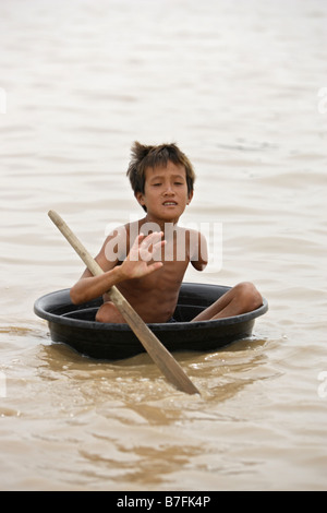 Left trans-humeral amputation on young boy paddling in plastic wash tub Stock Photo