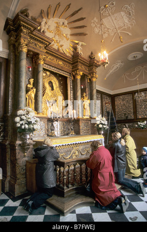 Polish pilgrims praying at Madonna of Gate of Dawn icon in Vilnius Lithuania Stock Photo
