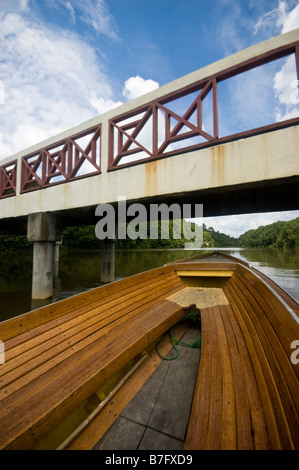 Boat going under bridge on tour of Brunei river and Kampung Ayer water village in Bandar Seri Begawan, Brunei Stock Photo