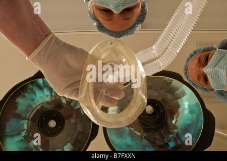 Anesthesiologist Surgery Nurse Looking Down At Patient Prior to General Anesthesia With Mask Coming down to Face Stock Photo