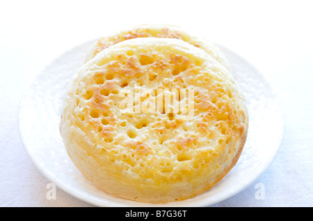 Close up of crumpets on white plate on white background. Stock Photo