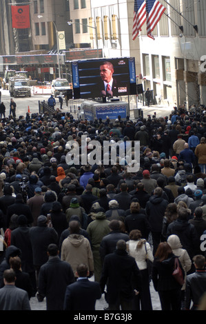 Spectators gather outside the New York Stock Exchange in New York to watch the inauguration of Barack Obama Stock Photo