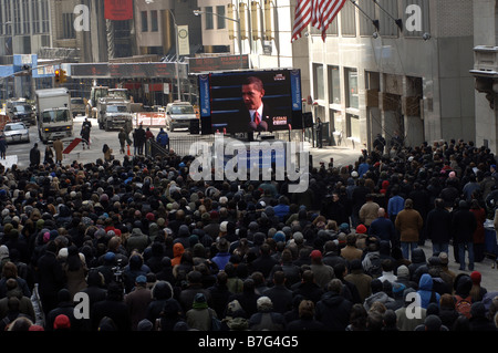 Spectators gather outside the New York Stock Exchange in New York to watch the inauguration of Barack Obama Stock Photo