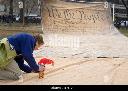 Person Signs Name to Replica of Preamble to US Constitution Stock Photo