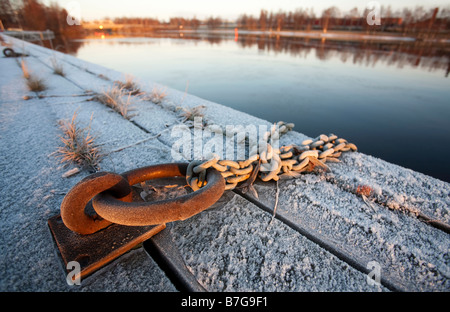 Old rusty iron mooring ring with chain attached to it , Finland Stock Photo