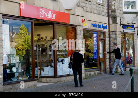 Shoppers passing and visiting charity shops in Ilkley, West Yorkshire Stock Photo