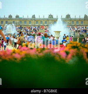 Tourists in flowered gardens during big waters play Chateau de Versailles France Stock Photo