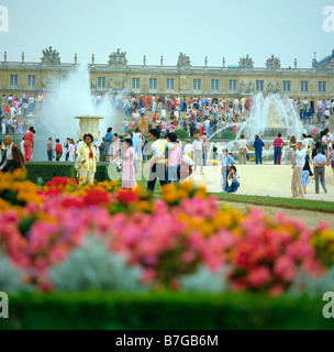 Tourists in flowered gardens during big waters play Chateau de Versailles France Stock Photo