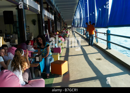 Young Turkish people enjoying an afternoon drink under Galata bridge in Istanbul Turkey Stock Photo