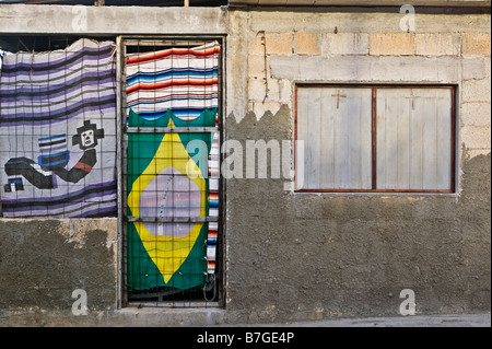 2 crosses in the window with flags and blankets for curtains on unfinished walls on Isla Mujeres, Mexico. Stock Photo