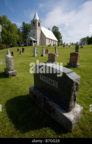 Church and Graveyard: A simple country church stands on a hill surrounded by gravestones Stock Photo