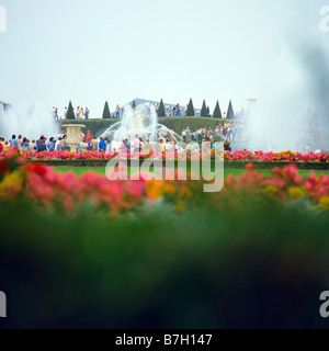 Tourists in flowered gardens during big waters play Chateau de Versailles France Stock Photo