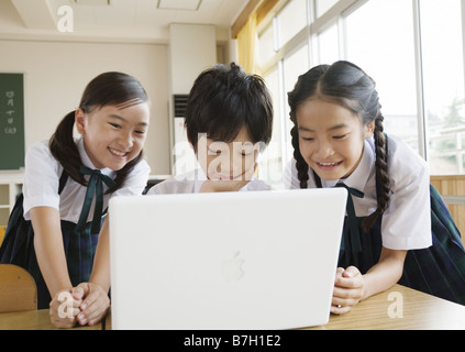 Elementary school students looking at laptop Stock Photo