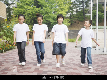 Elementary school students walking on schoolyard Stock Photo