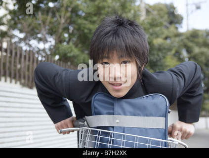 Teenageboy riding bike to school Stock Photo