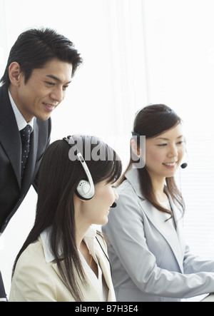 Operators and a businessman talking together Stock Photo