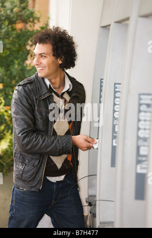 Middle Eastern man at ATM Stock Photo