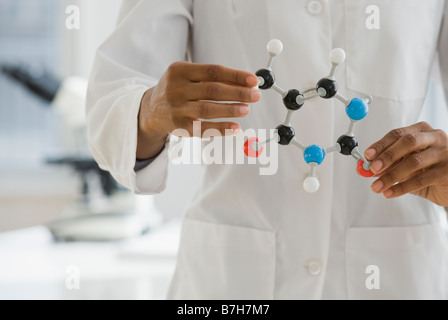 African scientist holding molecule model